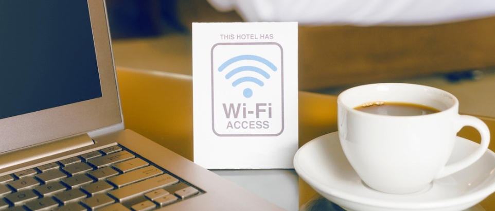 mesa com cafezinho e notebook com um placa com símbolo de wifi marketing